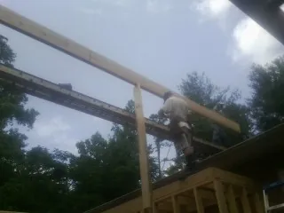 Carpenter setting a ridge beam over a new addition frame — Ice Dam Removal by Roofing Brothers in East Thetford
