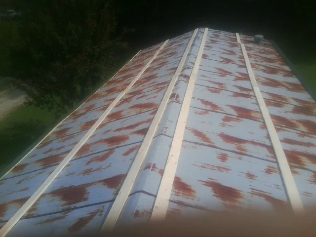 Rusted metal roof panels with new wood purlins before replacement — Storm Damage Roof Repair in East Thetford by Roofing Brothers