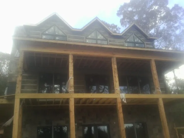 Dormers and porch framing on a large log home under construction — Roof Coating work by our crew in East Thetford