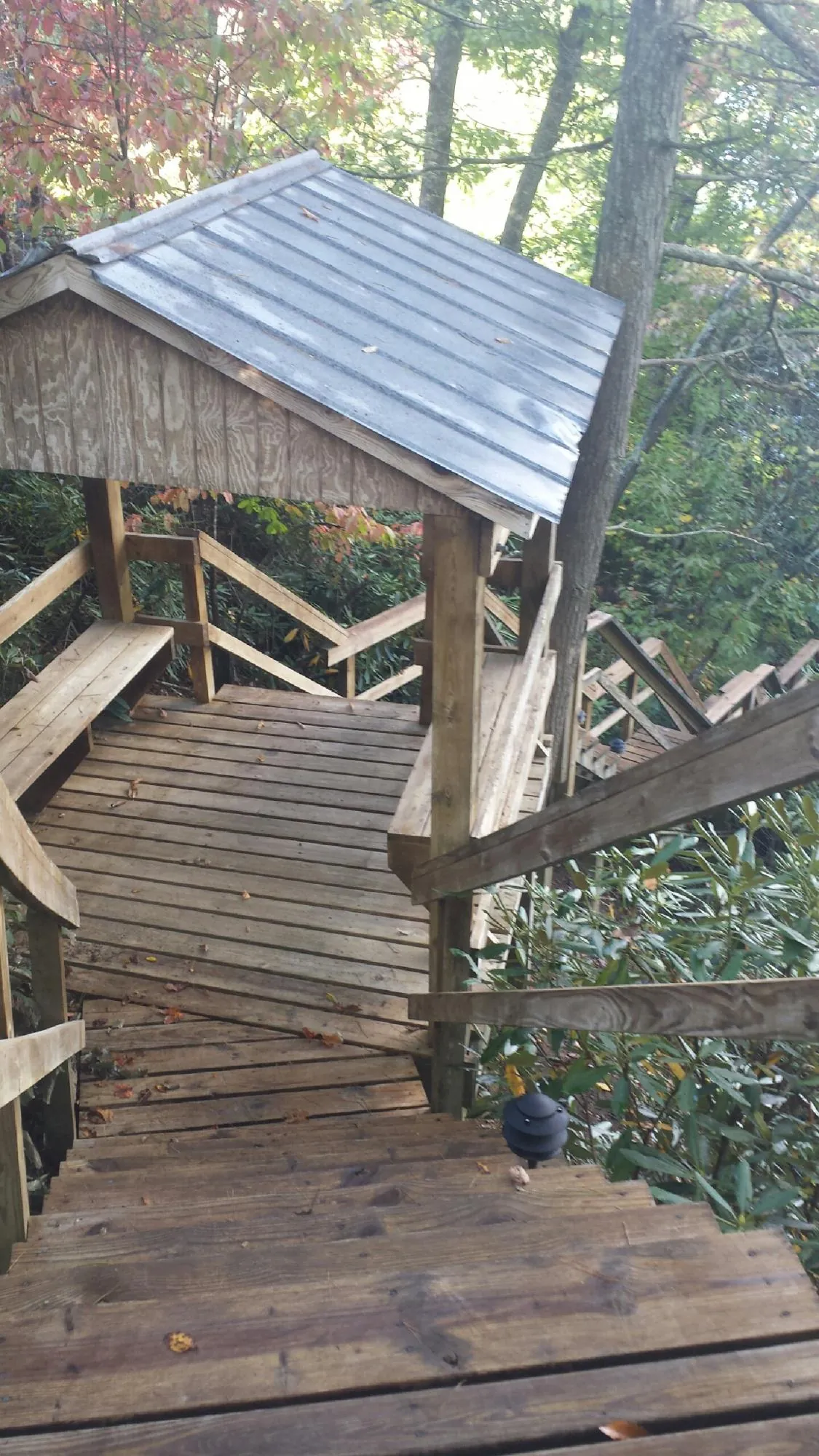 Metal roofed shelter over wooden steps on a wooded walkway — Skylight Repair & Installation work by our crew in East Thetford