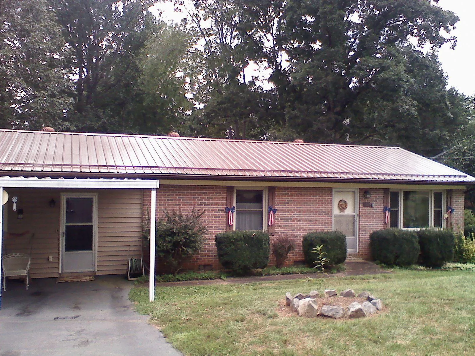 Bronze metal roof and carport on a brick ranch home — Roof Repair work by our crew in East Thetford